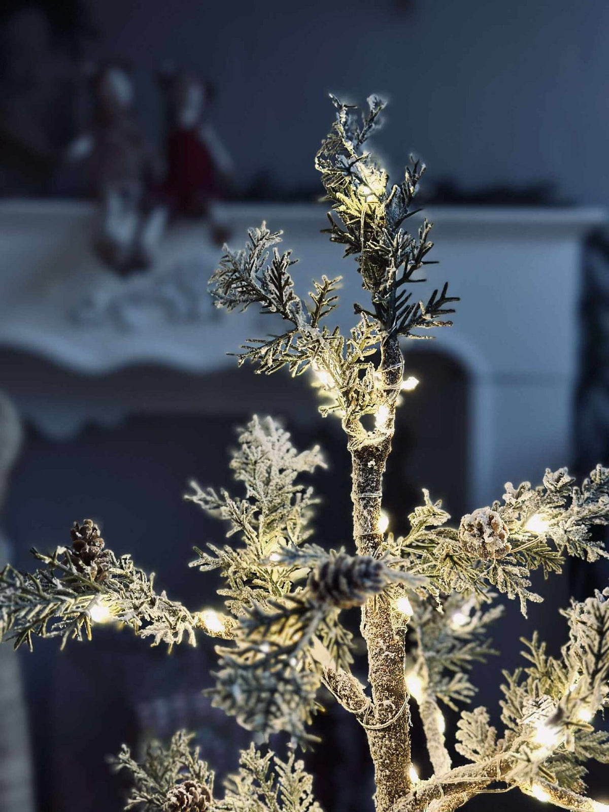 Arbre avec pommes de pin et guirlande lumineuse