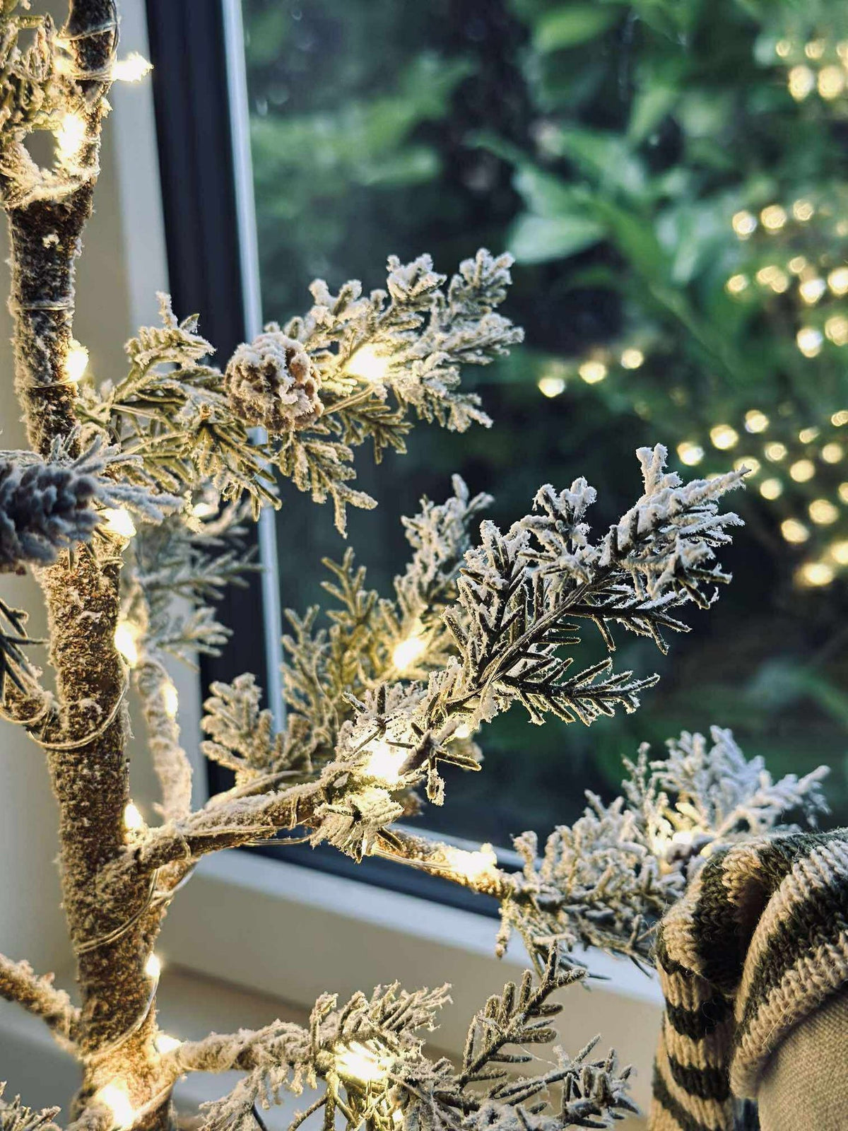 Arbre avec pommes de pin et guirlande lumineuse