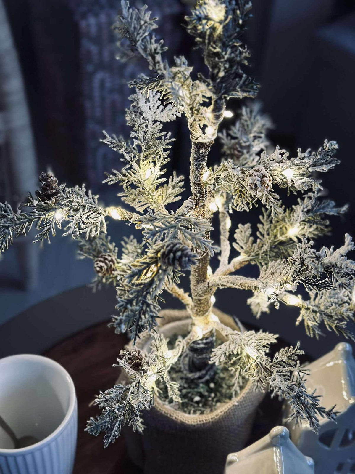 Arbre avec pommes de pin et guirlande lumineuse