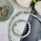 Collier Mary Jade vert à perles sur plateau gris et blanc